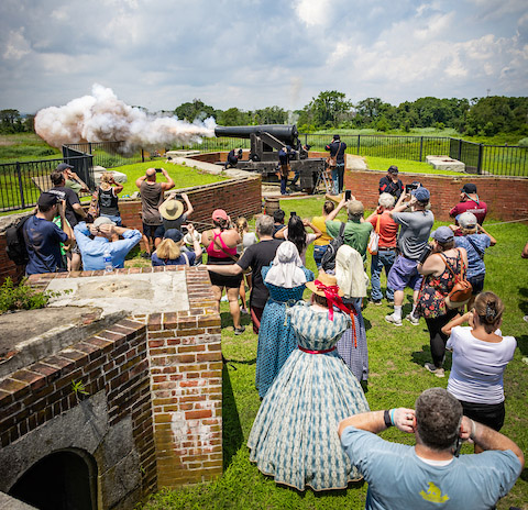 Visitors watching a cannon-firing demonstration with costumed interpreters at Fort Delaware